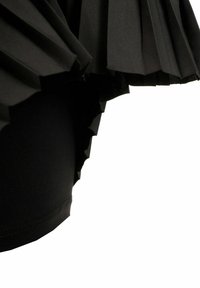 Tessuto nero plissettato con una finitura testurizzata, che forma un bordo arricciato sopra uno strato nero liscio e aderente sottostante.