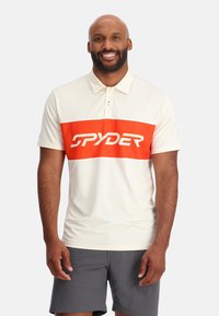 Helles Polo-Shirt mit einem kräftigen orangen horizontalen Streifen und dem "SPYDER"-Logo, gefertigt aus strukturiertem, atmungsaktivem Material.