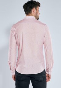 Rot-weißer gestreifter Langarmshirt mit Button-Down-Kragen, abgerundetem Saum und mit Knöpfen versehenen Manschetten, aus einem glatten Stoff gefertigt.