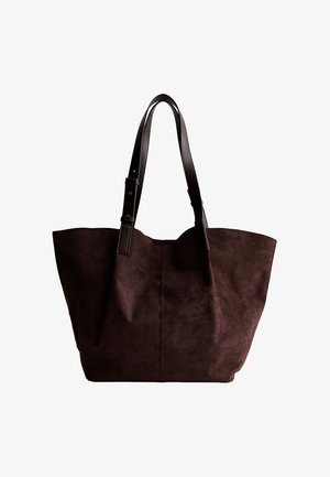 Borsa tote in suede marrone con un corpo spazioso, lati profondi e due manici robusti in pelle marrone per il trasporto. Nessun hardware visibile o decorazioni.