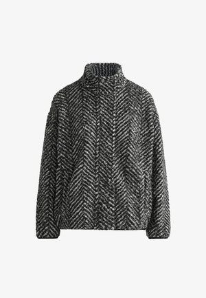 Czarny i biały polarowy sweter w wzór rybiej ości z wysokim kołnierzem i długimi rękawami. Miękka tekstura, luźny krój i brak widocznych zapięć.