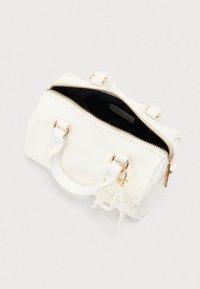 Λευκή υφασμάτινη τσάντα με χρυσά μεταλλικά στοιχεία, διπλές λαβές, κλείσιμο με φερμουάρ και διακοσμητικό γοργονέ με μαργαριτάρια. Το εσωτερικό είναι σκοτεινό.