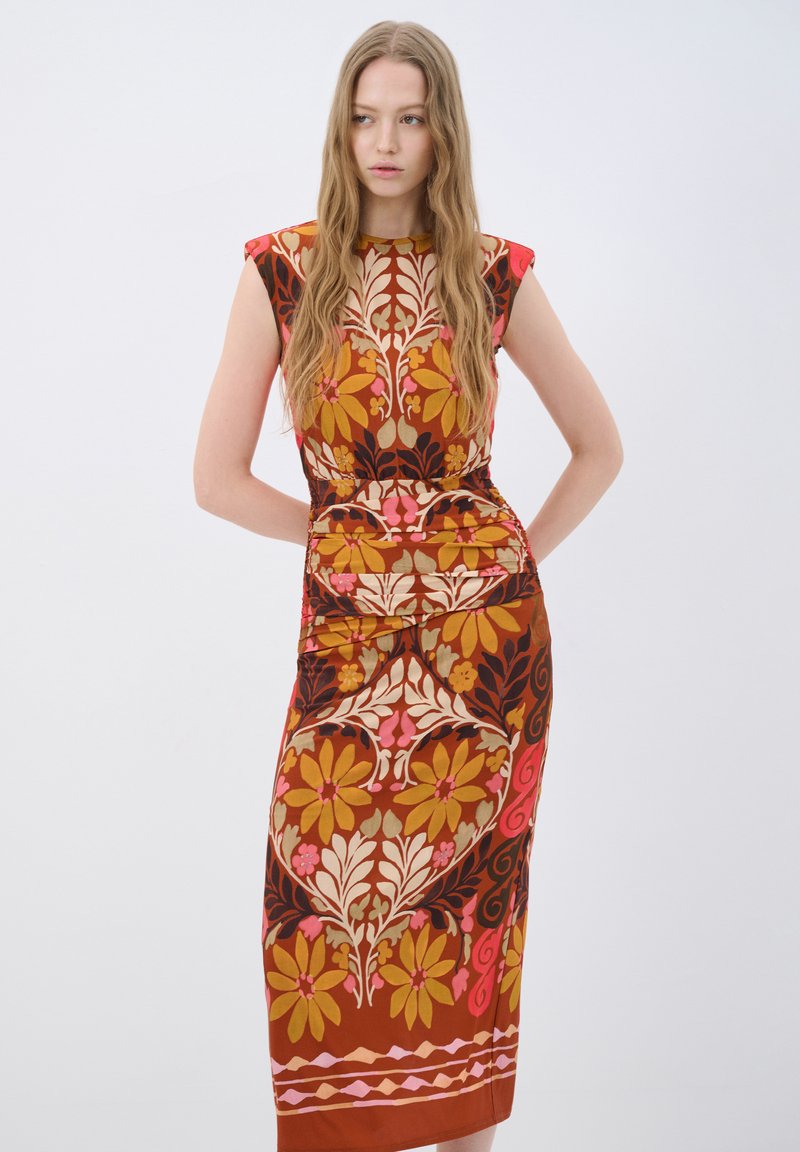 Maxi-jurk met een bloemenprint in warme tinten van oranje, roze en bruin. Aansluitende vorm met korte mouwen en geplooide details bij de taille.