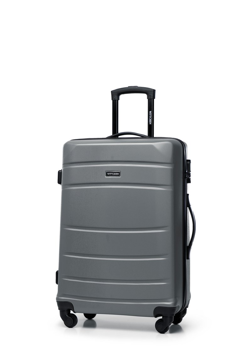 Gray hard-shell suitcase with a textured surface, featuring a retractable handle, four wheels, and a black zipper. Brand logo visible.