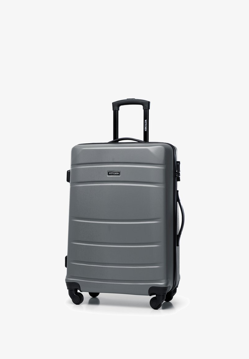 Gray hard-shell suitcase with a textured surface, featuring a retractable handle, four wheels, and a black zipper. Brand logo visible.