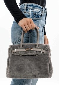 Grå faux fur taske med top-håndtag, sølv hardware og klaplukning. Tasken har en rektangulær form og tekstureret overflade.