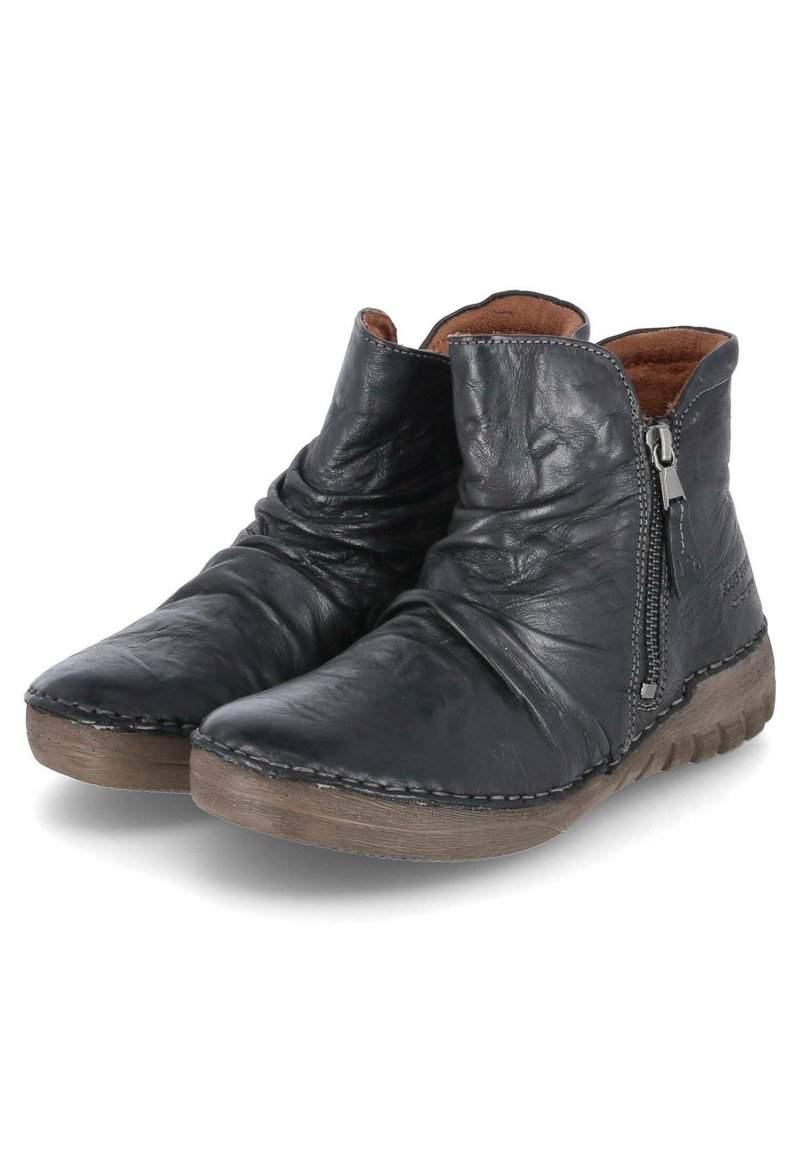 Bottes noires en cuir à la cheville avec texture froissée, fermeture éclair sur le côté et doublure intérieure marron. Semelle plate en caoutchouc avec des détails de couture.