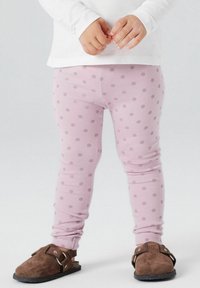 Lyserøde leggings med lavendelprikker, lavet af strækbart stof. Brune klipklapper med en justerbar rem fuldender looket.