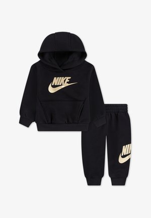 Čierna mikina a nohavice vyrobené z mäkkého materiálu, s veľkým zlatým logom Nike na prednej strane a na ľavom nohavici, s rebrovanými manžetami.