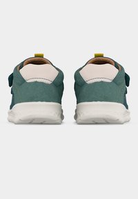 Ζευγάρι αθλητικών παπουτσιών σε τιρκουάζ και λευκό, εμφανιζόμενα από πίσω, με λευκές σόλες και κίτρινα λουράκια έλξης σε απλό φόντο.