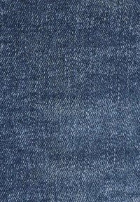 Denim fabric in dark blue with a textured weave; features varying shades of blue and subtle diagonal ridges, characteristic of classic denim.