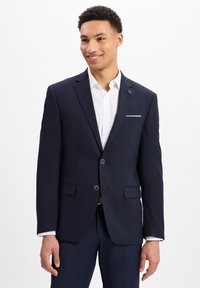 Granatowa marynarka z dwoma guzikami, z klapami i przednimi kieszeniami. Połączona z białą koszulą, ukazującą nowoczesny krój i gładką teksturę.