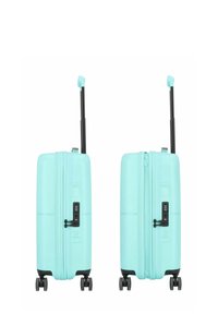 Valigia a mano rigida di colore turchese chiaro, dotata di zip, lucchetto a combinazione e quattro ruote girevoli per la mobilità. Inclusa maniglia telescopica.