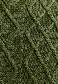 Dzianinowa poszewka na poduszkę w ciemnej oliwkowej zieleni, z teksturowanym wzorem w diamenty i siatkę. Miękki, gruby materiał z plecionym detalem w całej powierzchni.