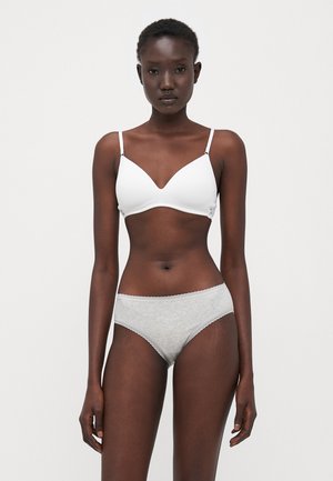White bra with a smooth, molded design paired with light gray cotton panties featuring a subtle lace trim. Model poses against a plain backdrop.