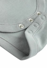 Body grigio in cotone, con scollatura rotonda, bottoni a pressione argentati e polsini a costine. Tessuto morbido con una finitura liscia.