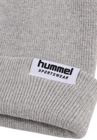 Gray knitted hat with a ribbed texture, featuring a folded cuff and a white label that reads "hummel SPORTSWEAR" in black.