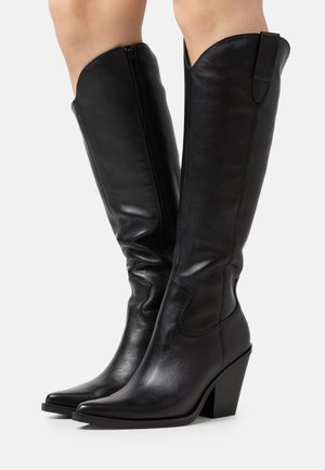 Bottes en cuir noir montantes avec un bout pointu, finition texturée, fermeture à glissière à l'arrière et un design de talon épais.