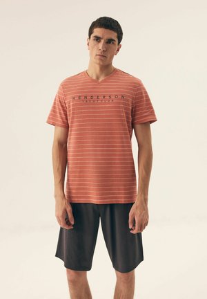 Rot gestreiftes kurzärmliges T-Shirt mit V-Ausschnitt, auf der Vorderseite mit schwarzem Text "HENDERSON YACHT CLUB" und kombiniert mit schwarzen Shorts.