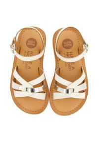 Sandalias blancas con tiras cruzadas y acentos plateados, que cuentan con una plantilla color tostado y una correa en el tobillo con detalle de hebilla.