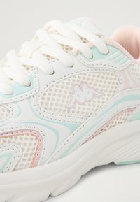 Sapatilha atlética branca com materiais em malha e couro, com detalhes em azul pastel e rosa. Logotipo notável na lateral. Sola texturizada.