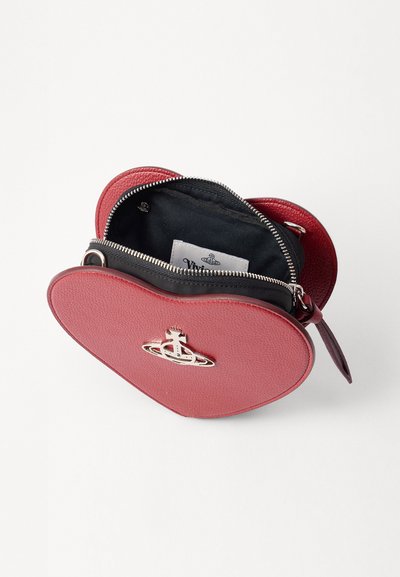 Borsa a forma di cuore in pelle sintetica rossa texture con interno nero. Presenta un logo in tonalità argento e una chiusura con zip. Dimensioni non specificate.