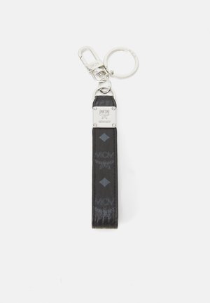 Breloșă din piele neagră cu clips metalic, având un logo MCM embosat și un model în diamante. Include un inel pentru chei rotund.
