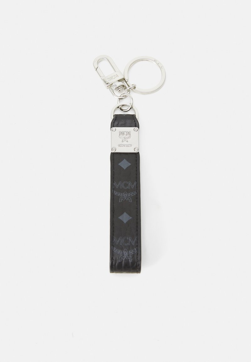 Svart skinnnøkkelring med metallklipp, med et preget MCM-logo og diamantskaping. Inkluderer en rund nøkkelringfeste.