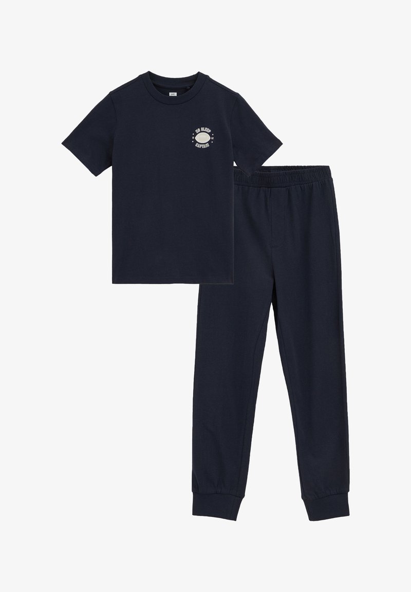 T-shirt bleu marine à manches courtes avec le texte « No Sleep Captain » et un graphique circulaire, associé à un pantalon de jogging taille élastique assorti.