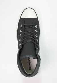 Svart hög sneaker med övre i canvas, gummikåpa och vit sula. Utrustad med silverfärgade öglor och platta svarta snören.