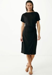 Abito nero fino al ginocchio con maniche corte, caratterizzato da un design annodato in vita. Tessuto morbido e liscio con una vestibilità comoda.