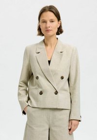 Beige linned dobbeltrækket blazer med notched lapels, to forlommer og brune knapper. Glat tekstur og skræddersyet pasform.