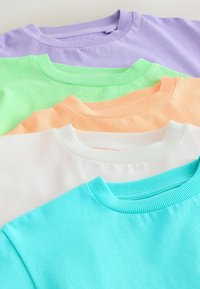 Cinq sweatshirts à col rond pliés dans des couleurs pastel : lavande, vert clair, pêche, blanc et turquoise, empilés soigneusement.