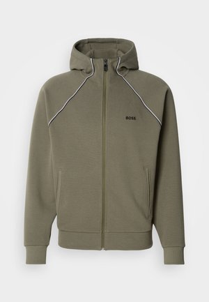 Alyvuogių žalumos užsegama su užtrauktuku džemperis iš minkštos medžiagos, su gobtuvu, baltomis juostelėmis ant pečių ir dviem šoninėmis kišenėmis.