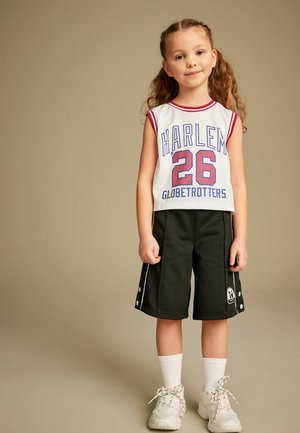 Valkoinen pelipaita punaisilla yksityiskohdilla, laivastonsininen "HARLEM 26 GLOBETROTTERS" -teksti. Mustat shortsit valkoisilla yksityiskohdilla ja sivunappiyksityiskohdalla. Valkoiset sukat ja kengät.