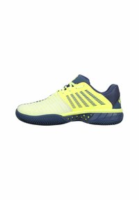 Sportschuhe mit einem Design in Gelb und Marineblau, Obermaterial aus Synthetik mit strukturierten Streifen, Gummisohle und einem markanten Fischgrätenprofil.