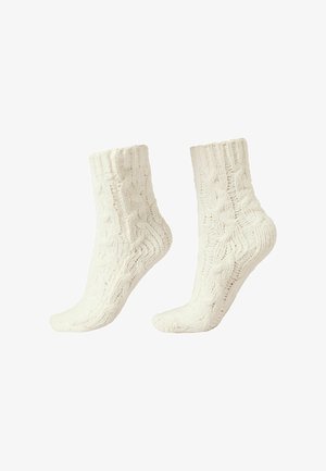 Weiße gestrickte Socken mit einem Zopfmuster, mit gerippten Bündchen, einer strukturierten Oberfläche und einem Design bis zur Mitte der Wade.