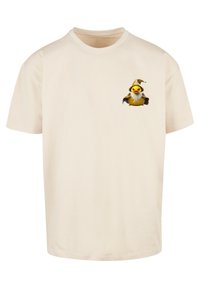 Beige cotton t-shirt with a round neckline. Features a cartoon wizard duck graphic on the left chest area. Short sleeves, standard fit.