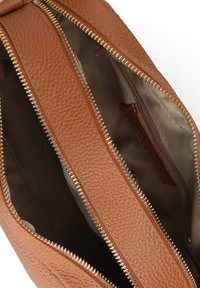 Borsa a tracolla in pelle marrone aperta, con texture a ciottoli, due scomparti con zip e fodera interna in tessuto beige.