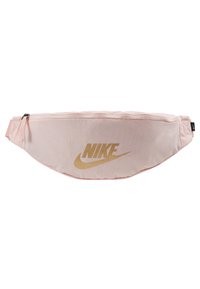 Světle růžová ledvinka vyrobená z odolné tkaniny, s zlatým logem Nike a zapínáním na zip. Kompaktní design s nastavitelným popruhem.
