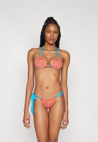 Bikini floreale rosso con spalline blu; parte superiore a triangolo e parte inferiore a vita bassa con chiusura a laccio; presenta piccoli motivi floreali multicolori.
