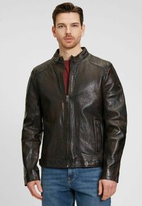 Braune Lederjacke mit hohem Kragen, Vorderreißverschluss und seitlichen Taschen. Die Textur ist glatt mit einem dezenten Glanz und leicht verwaschenem Finish.