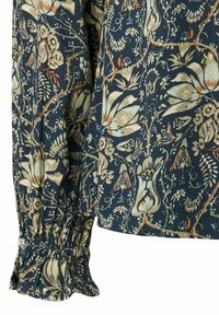 Chemise à motifs floraux avec un fond marine, ornée de fleurs pastel. Les manches présentent un design de poignet froncé pour ajouter de la texture. Fabriquée en coton.