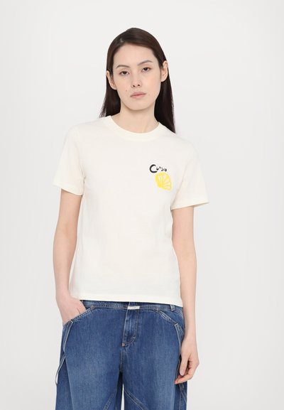 Cremfarbens Baumwoll-T-Shirt mit kurzen Ärmeln, rundem Halsausschnitt und einem gelben Zitronenmotiv mit schwarzen Akzenten auf der Brust.