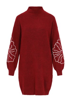 Czerwony sweter dzianinowy z wysokim kołnierzem, zbyt dużymi rękawami oraz białymi haftami kwiatowymi na każdym rękawie, charakteryzujący się teksturowanym, miękkim wykończeniem.