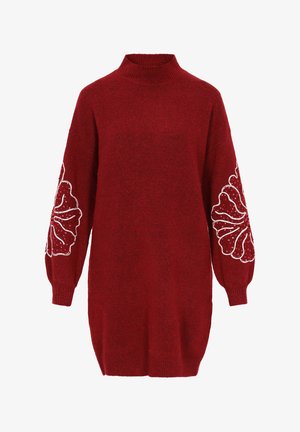 Czerwony sweter dzianinowy z wysokim kołnierzem, zbyt dużymi rękawami oraz białymi haftami kwiatowymi na każdym rękawie, charakteryzujący się teksturowanym, miękkim wykończeniem.