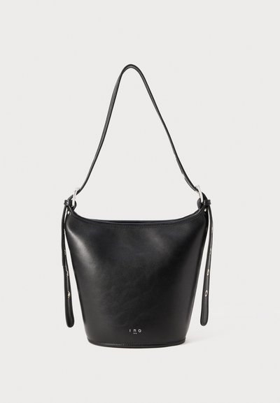 Bolso de cuero negro tipo bucket con correa ajustable y herrajes plateados, pequeño logo "IRO Paris" en el centro inferior.