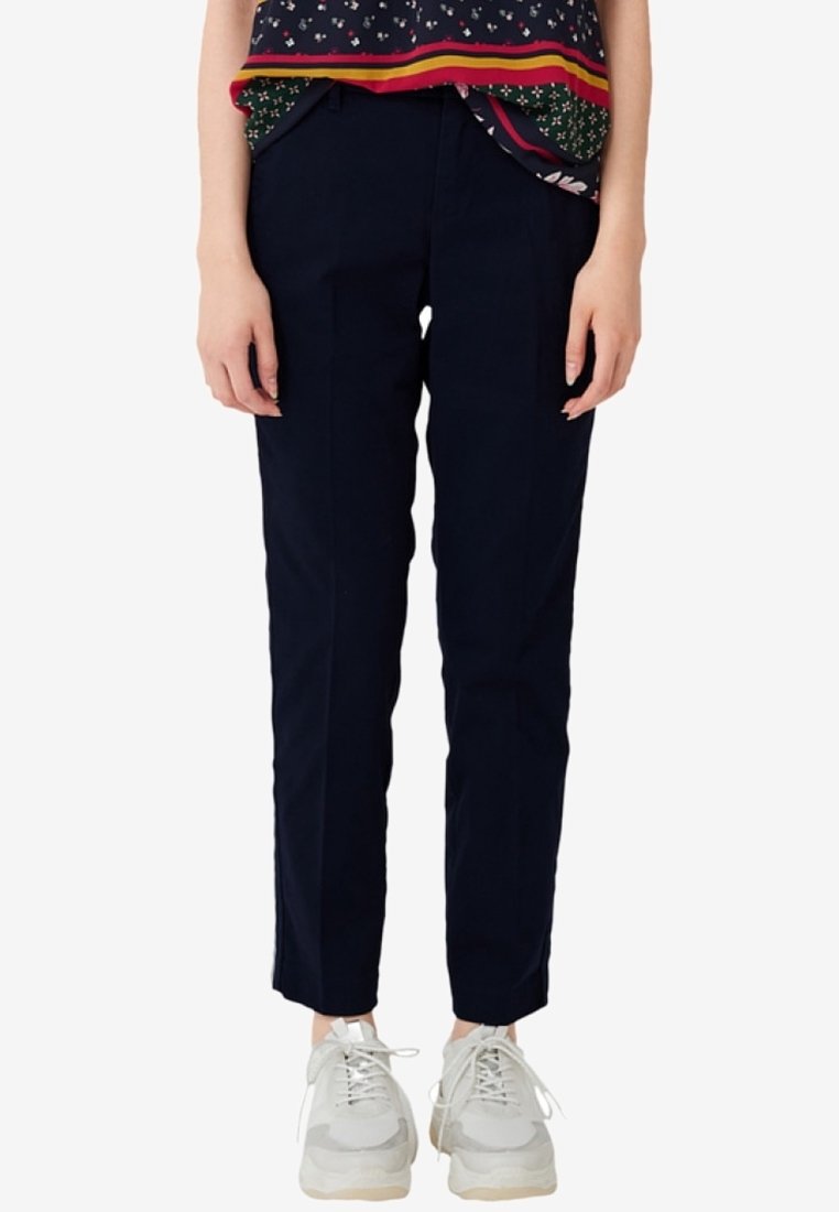 Pantalon bleu marine léger à coupe droite avec plis à l'avant, associé à un haut multicolore à motifs et des baskets grises.