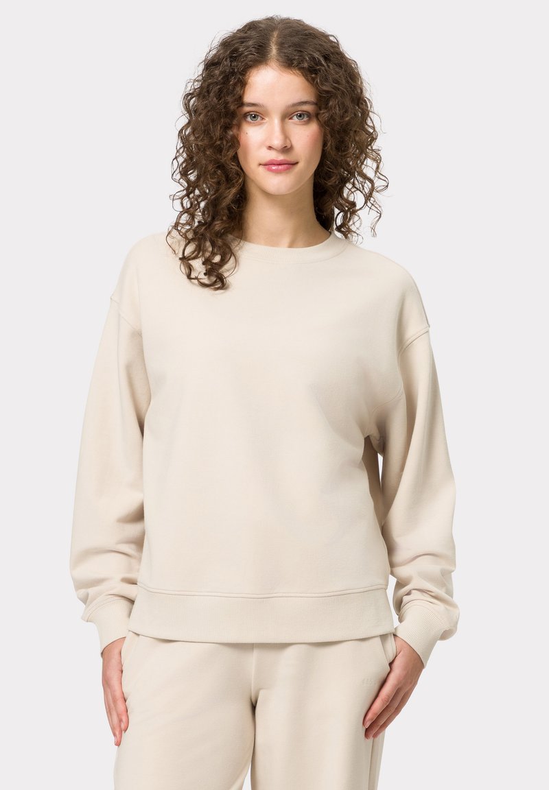 Felpa beige con vestibilità rilassata, scollo rotondo e maniche lunghe. Realizzata in un tessuto morbido con polsini e orlo a costine.