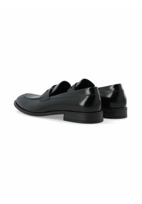 Schwarze Lederschuhe mit einer glatten, glänzenden Oberfläche, ausgestattet mit einem niedrigen Absatz und einem schlichten Design. Die Rückseite ist leicht abgerundet und im Slip-on-Stil.